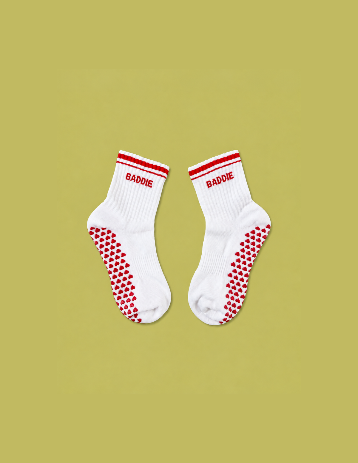 White BADDIE Pilates grip socks with red varsity stripes and heart-shaped non-slip grips by CHEEKYBEEN
